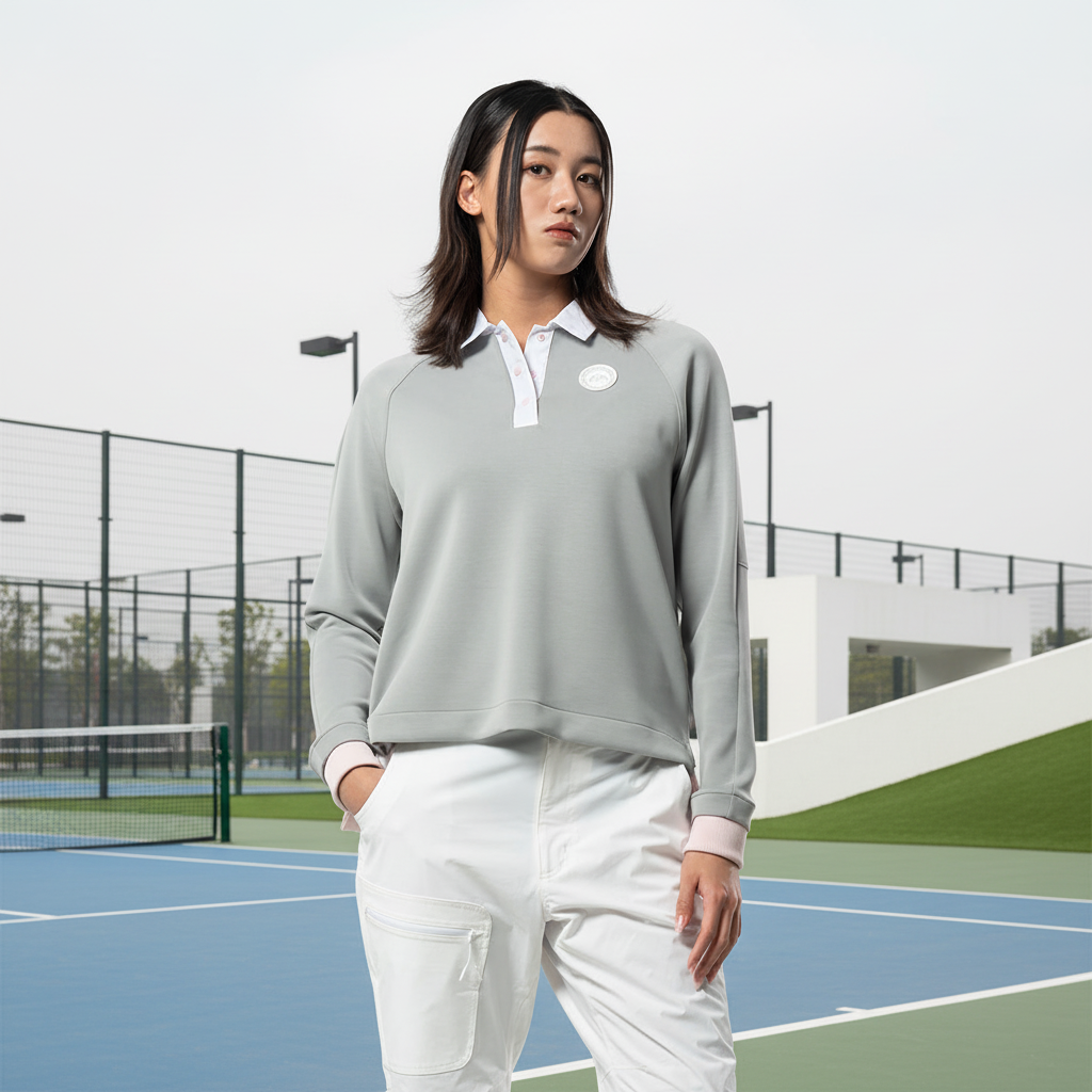 Image of Female model in grey polo sweatshirt with outdoor sporty background